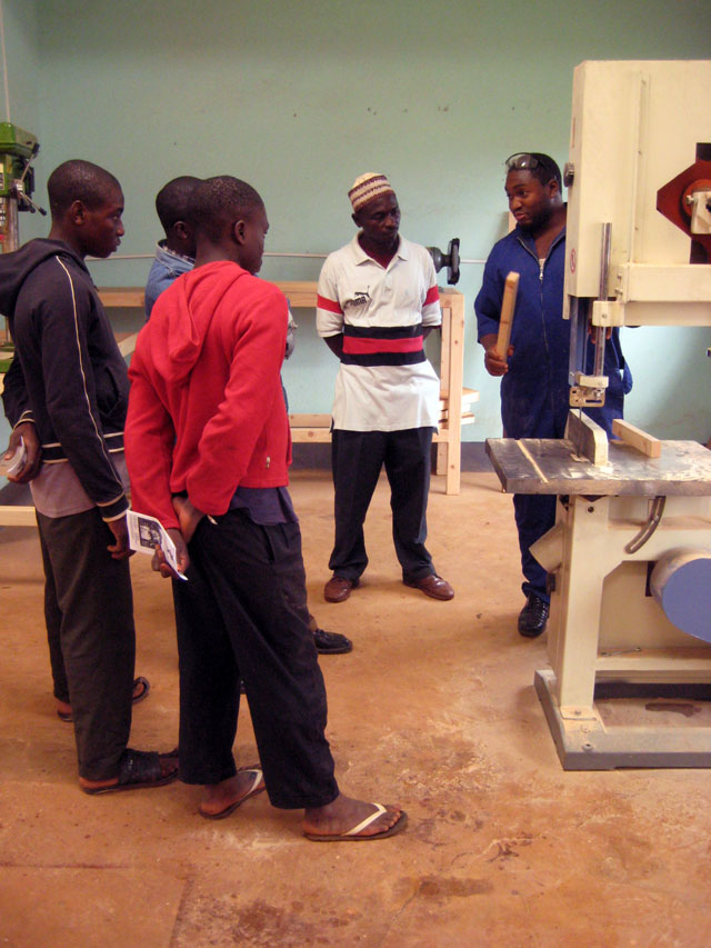 Victor, one of the Carpentry & Construction students, explains the various uses of the band saw, which is an entirely new tool in Kumbo.