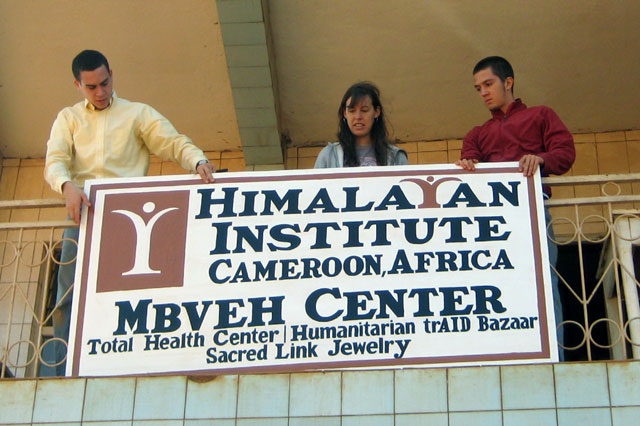 John Daskovsky, Chelsea Abella, and Rylan Grady hang the sign for the new Mbveh Center